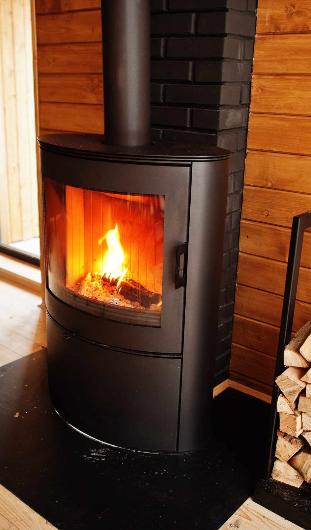 Fireplace with woods in modern wooden house.